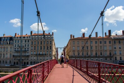 A couple walks down Lyon's St. Vincent bridge