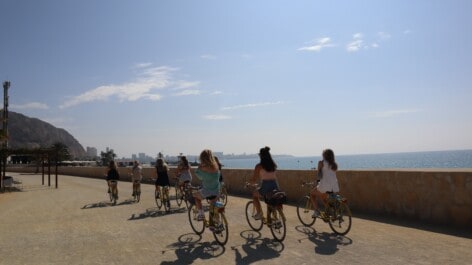Cyclists riding along the water in Alicante
