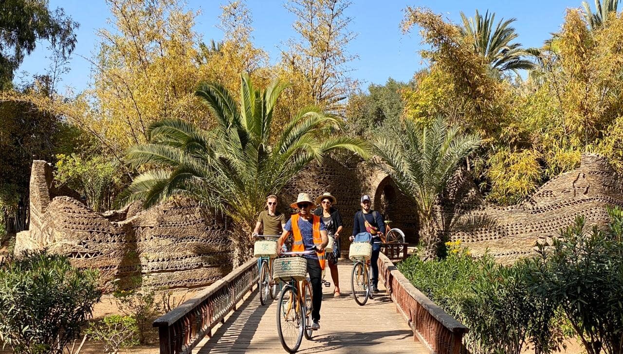 A group of cyclists ride across a bridge in a green area of Agadir-