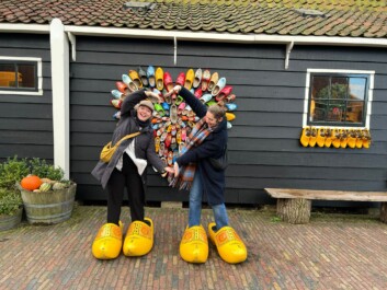 2 women stand in giant wooden clogs